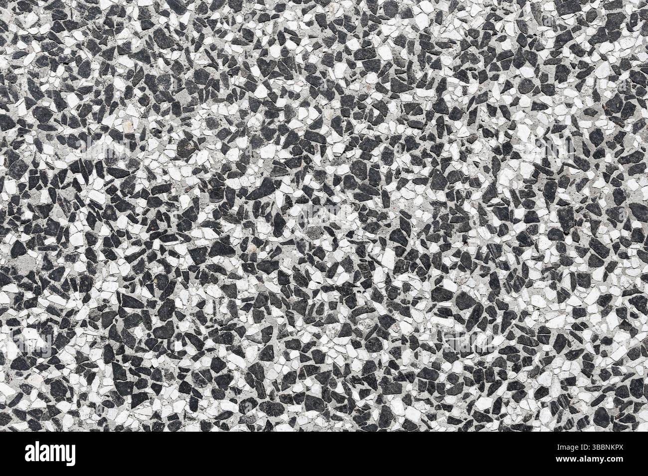 Superficie del pavimento in terrazzo in pietra. Texture a mosaico grigio e bianco. Schema di costruzione astratto. Sfondo decorativo senza cuciture. Foto Stock