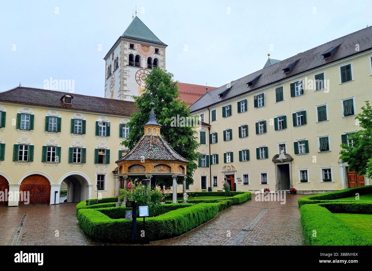 Vista di un grazioso gazebo su un prato verde nel cortile dell'abbazia medievale di Novacella in alto Adige, Italia Foto Stock