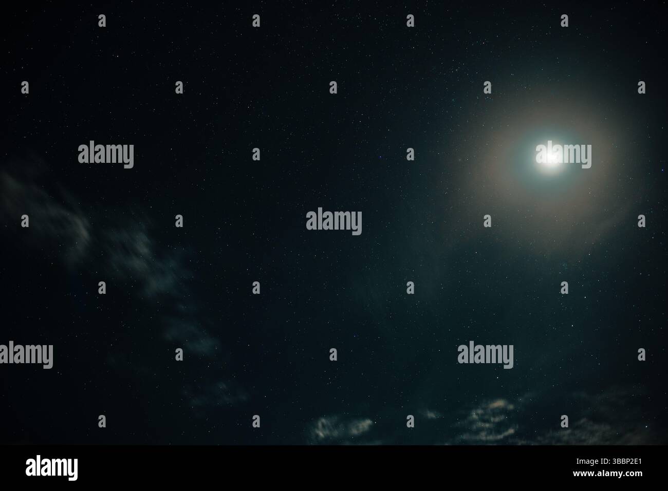 La luna risplende nel cielo notturno con stelle e nuvole Foto Stock