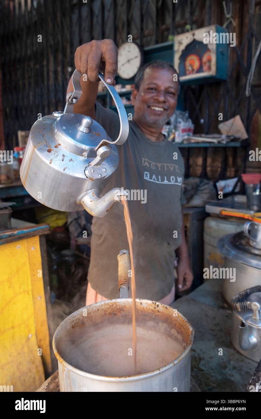 Il proprietario del chiosco di strada è orgoglioso di versare una tazza di latte chai, Kolkata, Calcutta, Bengala Occidentale, India Foto Stock