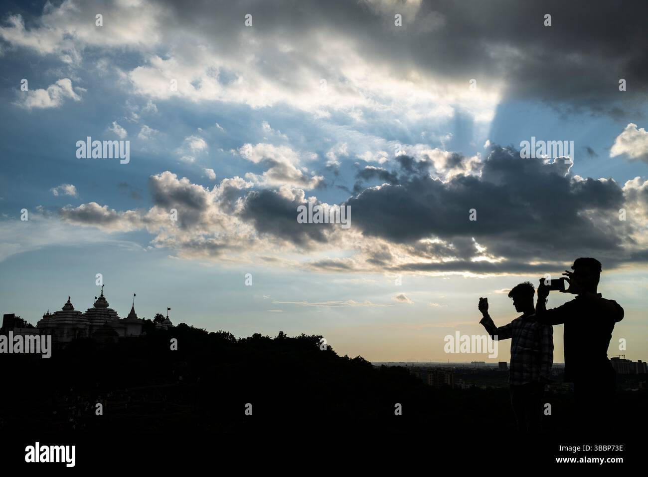 Al tramonto i visitatori scattano foto dalla cima della collina del tempio Digambara Jaina, Bhubanesswar, Orissa, India Foto Stock