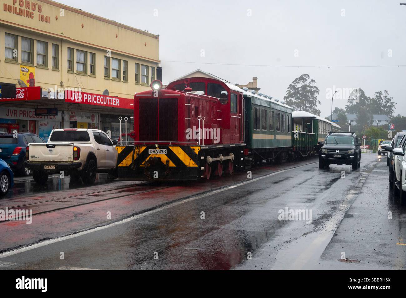 Il treno della Bay of Islands Vintage Railway attraversa la strada principale di Kawakawa, Bay of Islands, North Island, nuova Zelanda Foto Stock
