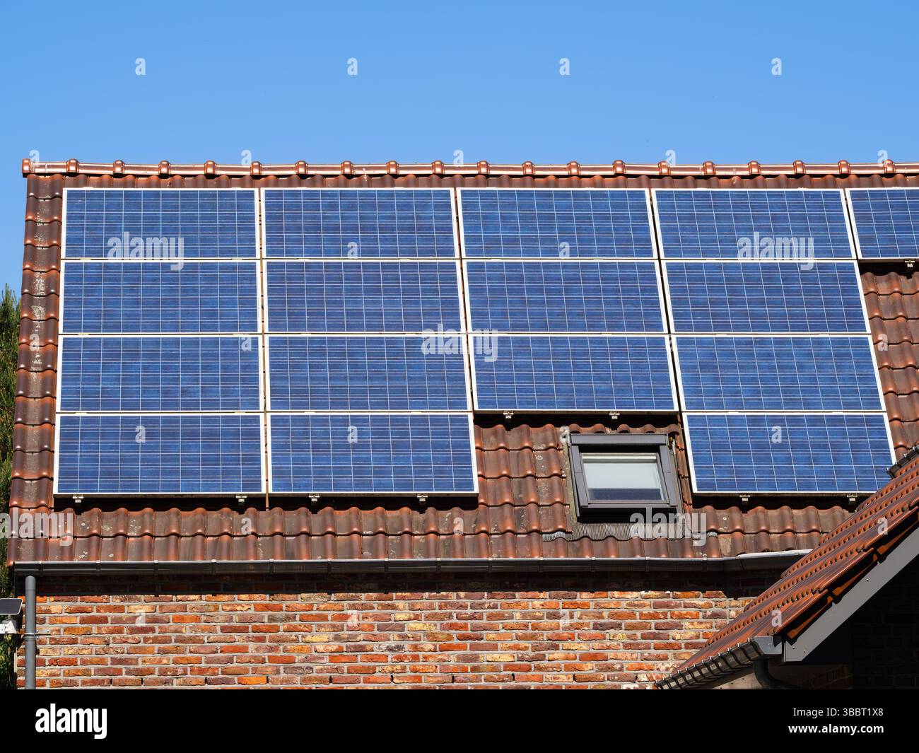 Un tetto con pannelli solari installati, che mostra la tecnologia delle energie rinnovabili contro un cielo azzurro. Foto Stock