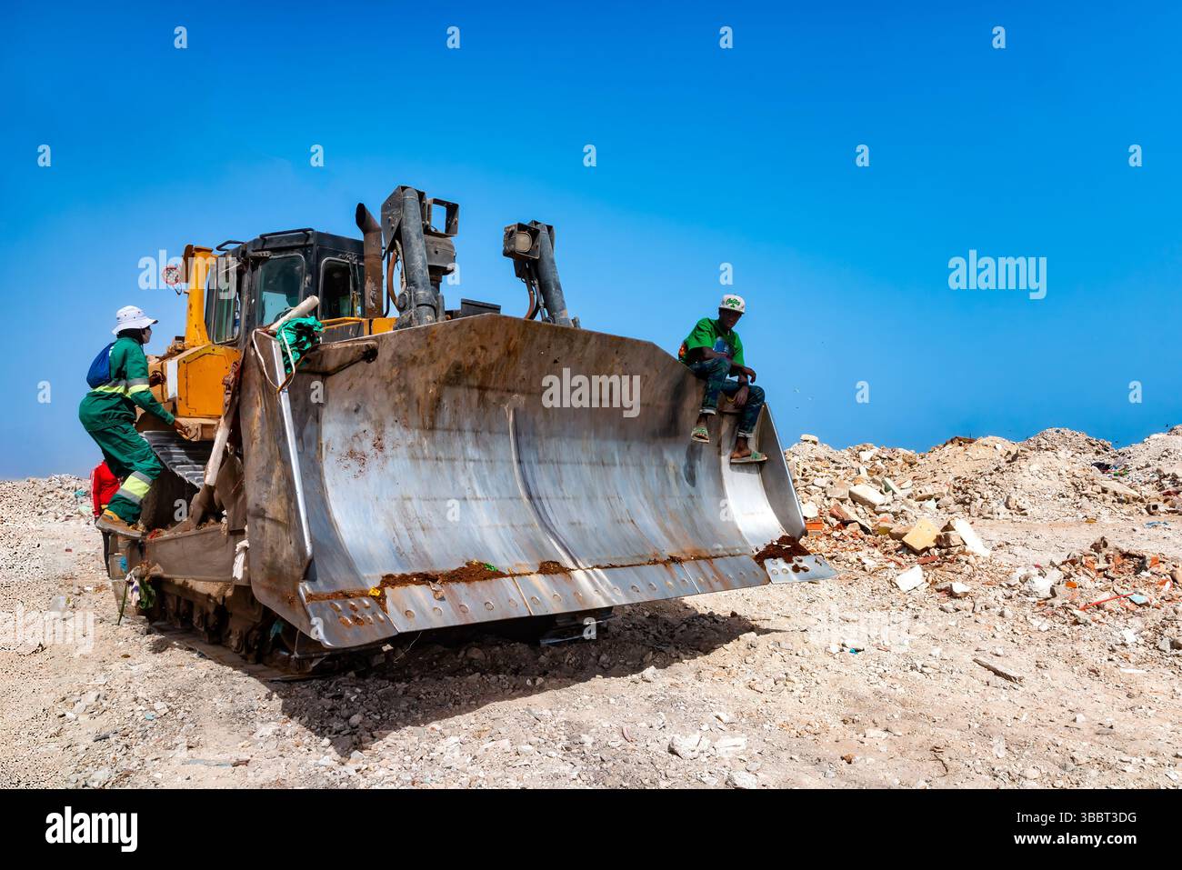Dakar, Senegal - 2 maggio 2024: I lavoratori gestiscono un bulldozer nella discarica Mbeubeuss di Dakar, Senegal, navigando attraverso vasti pali di rifiuti Foto Stock