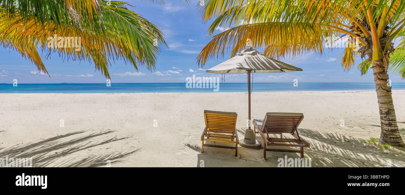 Sole spiaggia tropicale con sedie colorate ombrelloni, perfetto relax per il tempo libero sul paradiso dell'isola, scenario panoramico sullo sfondo Foto Stock