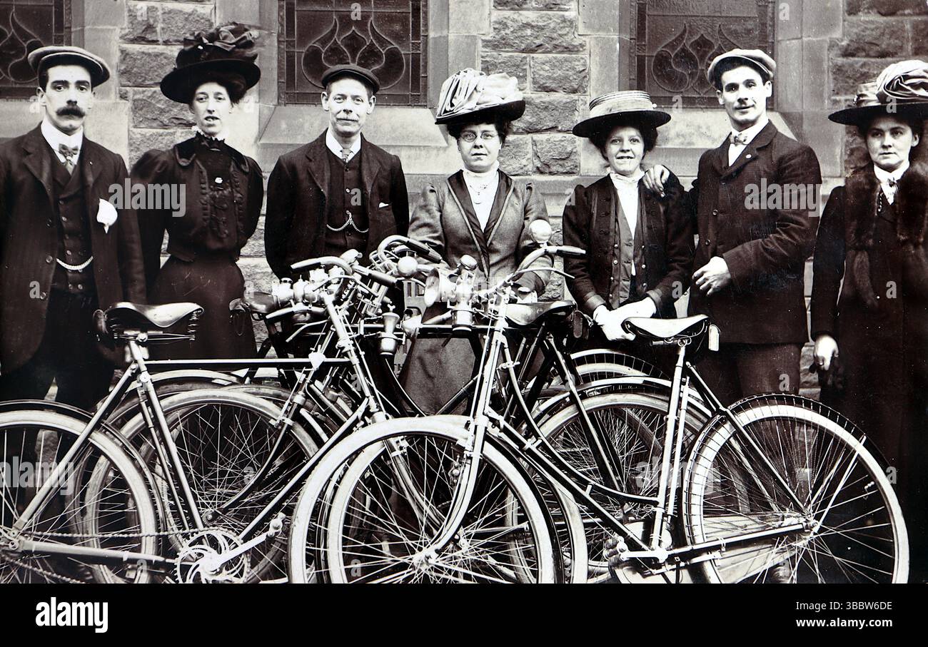 Storia sociale, ciclismo: Un gruppo di sette persone, tre signori e quattro signore, tutti in piedi, le loro biciclette davanti a loro. Gli uomini indossano abiti, abiti da donna o gonne, e tutti hanno cappelli. Non attribuito, inglese, forse fuori da una chiesa, intorno al 1908. Da una collezione mista di cartoline edoardiane. Foto Stock
