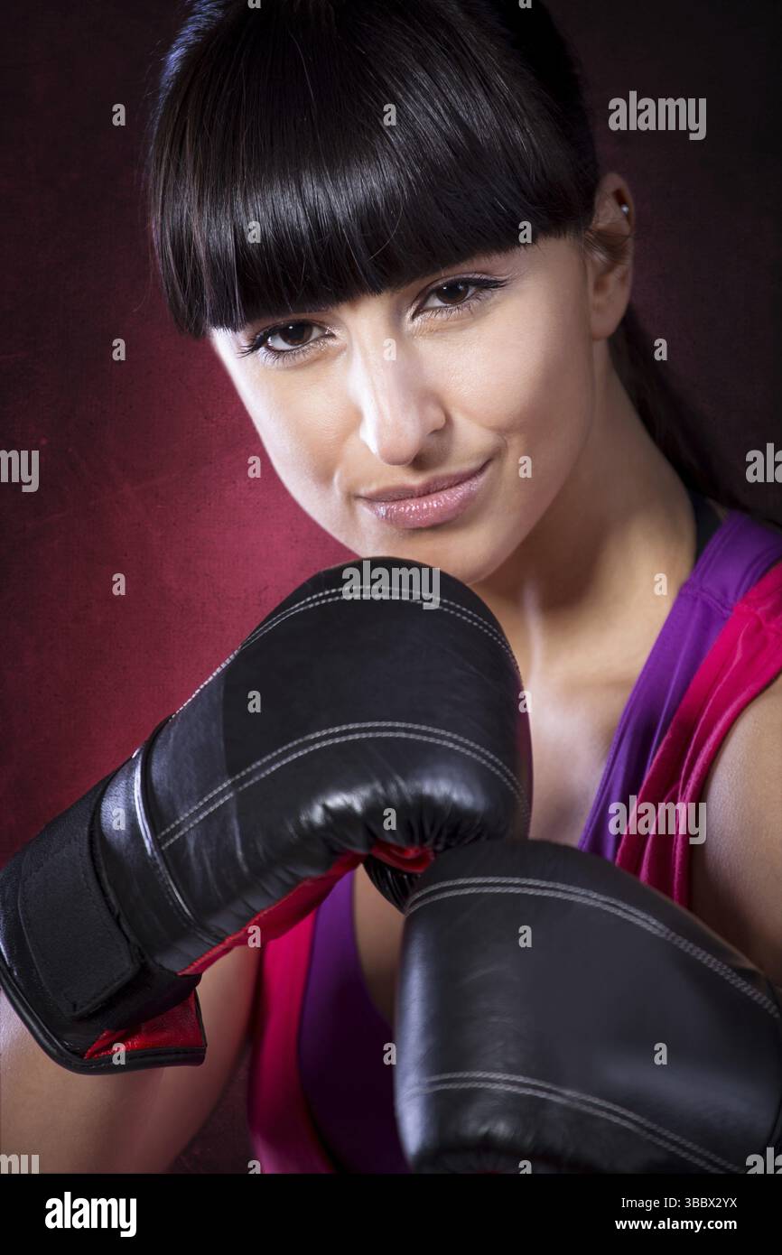 Giovane donna in abito sportivo all'esercizio di pugilato Tae Bo Foto Stock