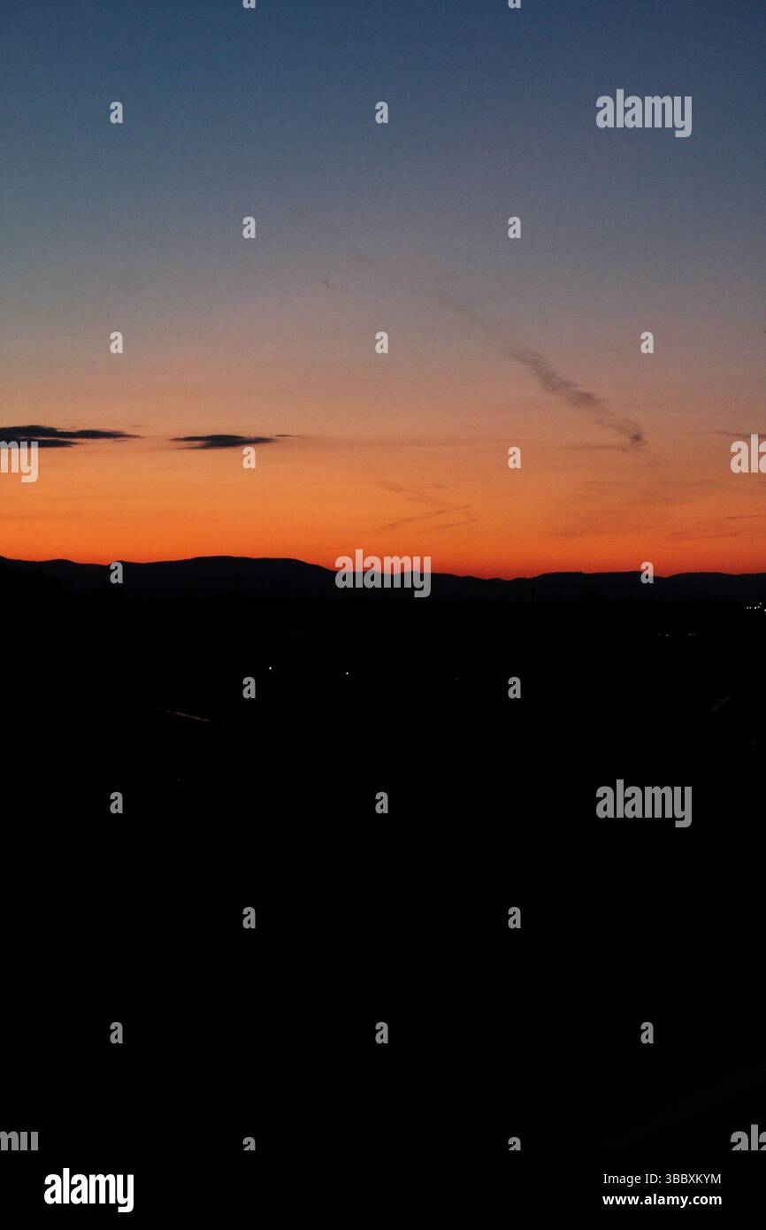 Cielo crepuscolo con orizzonte luminoso e colline lontane Foto Stock