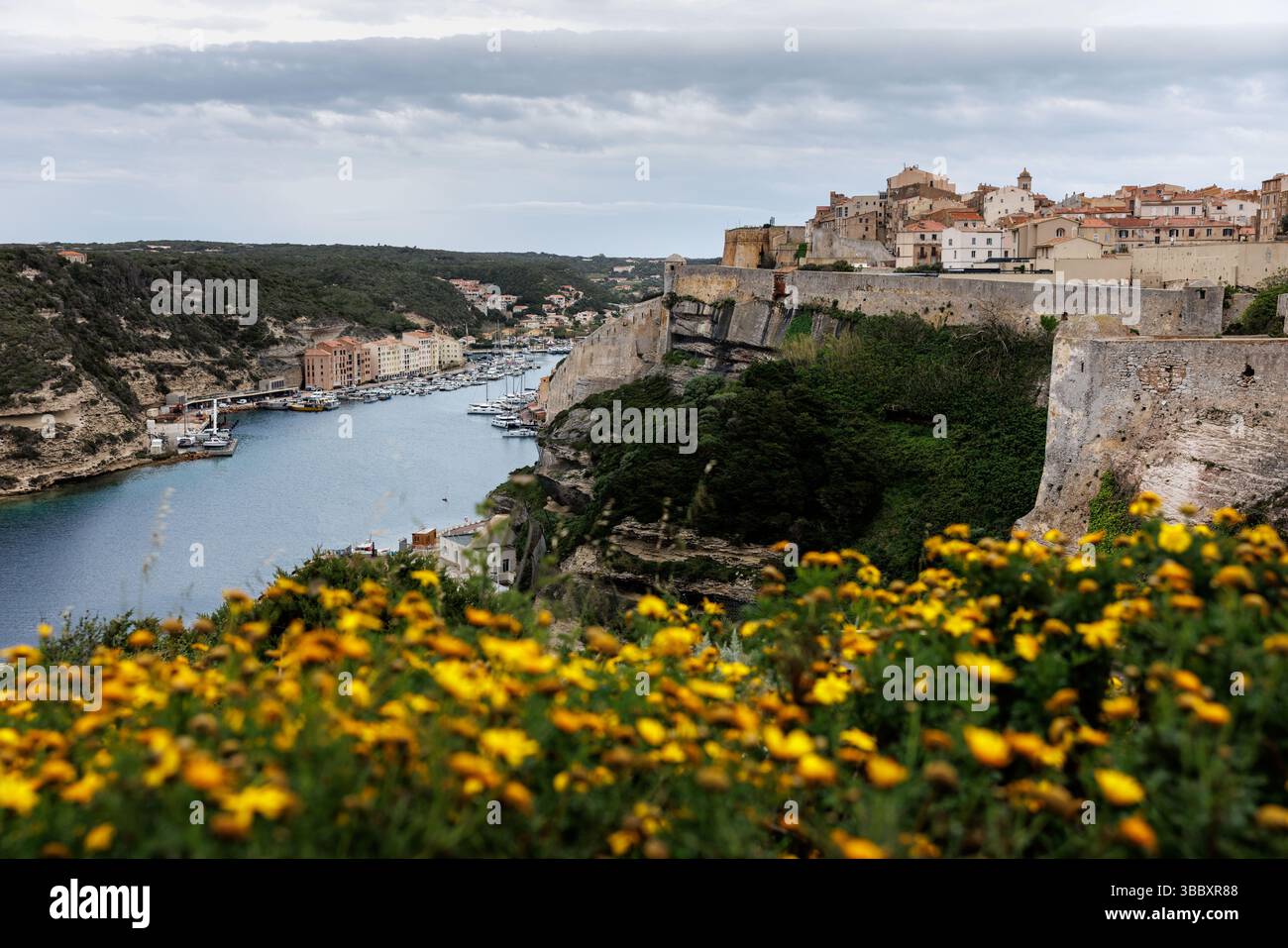 20 aprile 2025, Francia, Bonifacio: Veduta della città di Bonifacio sull'isola di Corsica (Francia) il 20.04.2025. È possibile vedere il centro storico medievale (Ville haute) su un promontorio di pietra calcarea e arenaria, che degrada verticalmente in gran parte verso il mare, nonché il porto e la città bassa di Bonifacio nella baia di Calanque de Fazio, simile a un fiordo. Bonifacio (corso Bunifaziu; Ligure Bunifazziu o Bonifacio) è una città portuale situata nel sud dell'isola francese del Mediterraneo della Corsica (Corsica) nel dipartimento della Corsica del Sud. Situato su un altopiano roccioso simile a una penisola, il vecchio Foto Stock