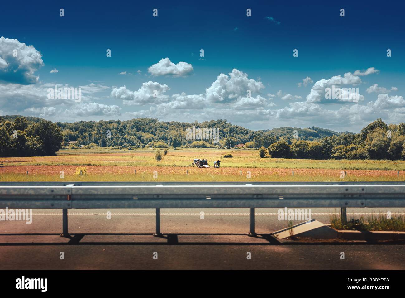 Una coppia di anziani sposati in campagna, che lavora con un trattore sul campo, una giornata di primavera nuvolosa nella Serbia centrale, vista dal Milos Veliki h Foto Stock