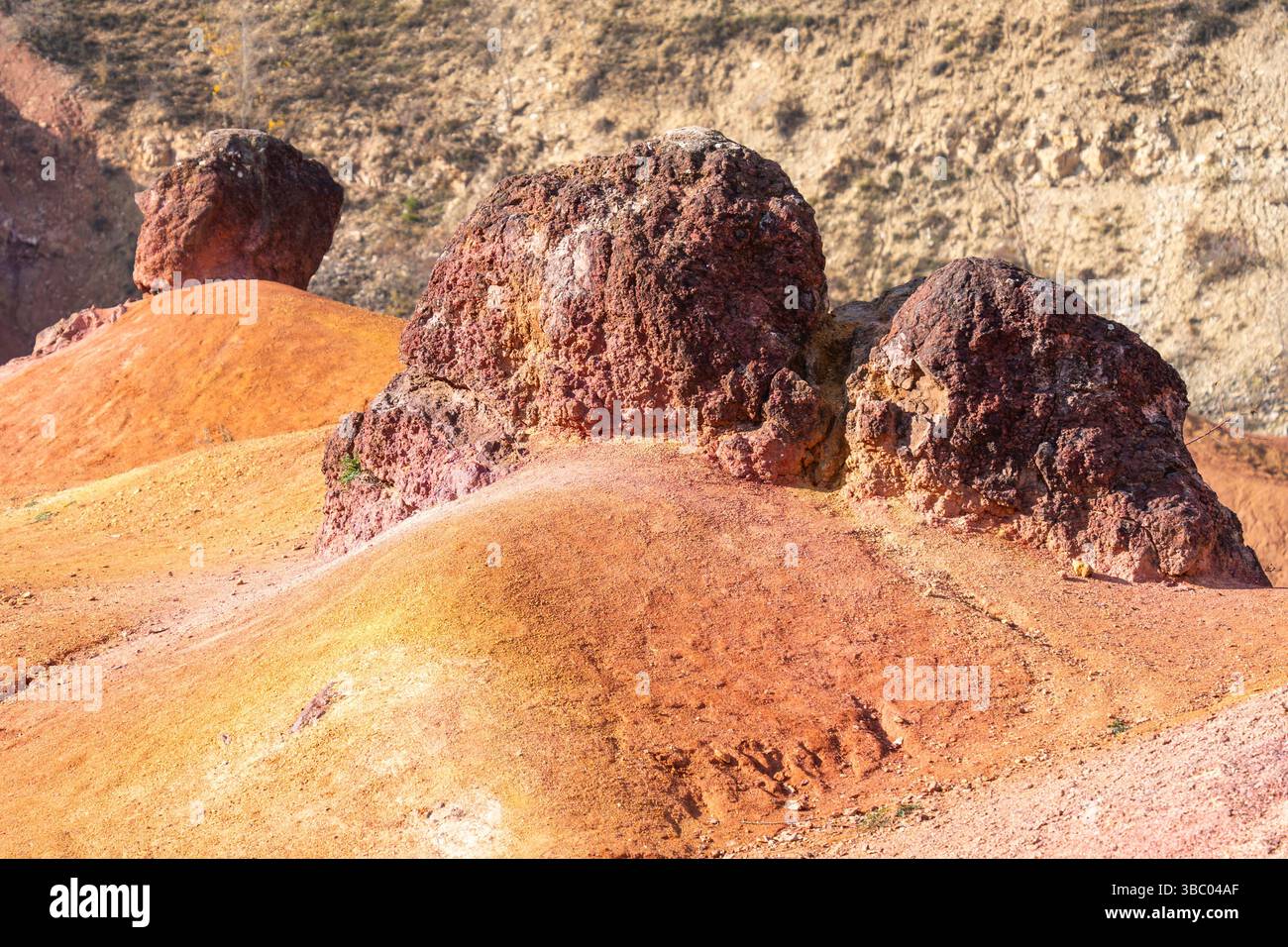 Formazione rocciosa di bauxite erosa con colori arancio brillanti in una miniera di bauxite abbandonata Foto Stock