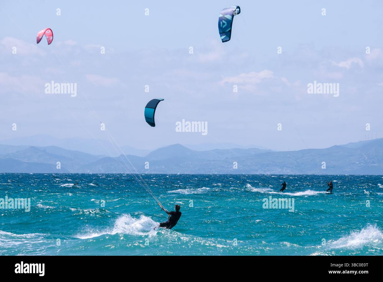 Kitesurfers lungo lo stretto di Gibilterra a Tarifa, Spagna. Il Marocco è visibile in lontananza. Foto Stock