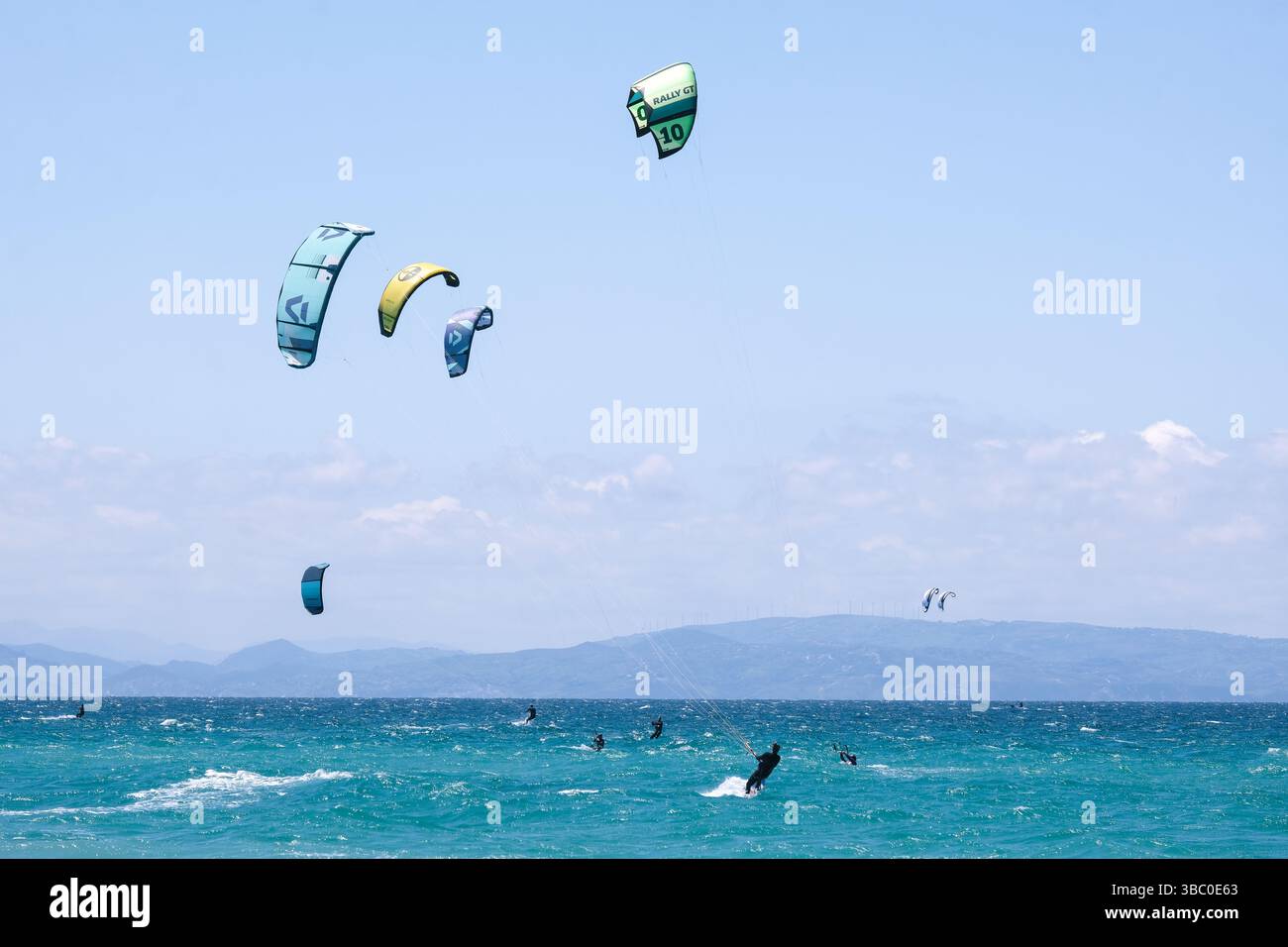 Kitesurfers lungo lo stretto di Gibilterra a Tarifa, Spagna. Il Marocco è visibile in lontananza. Foto Stock
