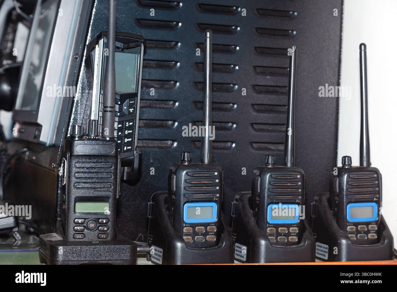 Molti walkie-talkie si trovano nei caricabatterie e si caricano. Foto Stock