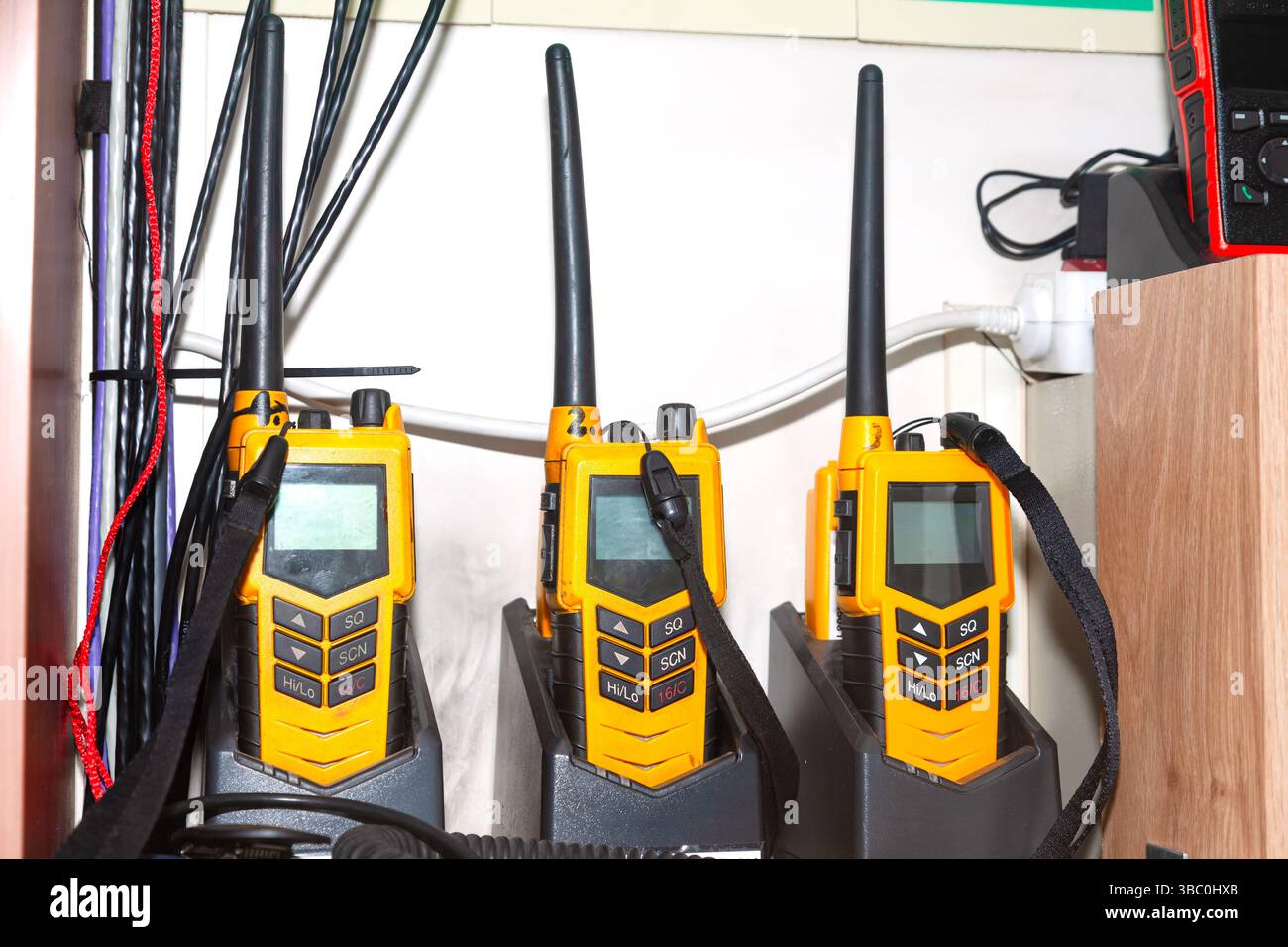 Molti walkie-talkie si trovano nei caricabatterie e si caricano. Foto Stock