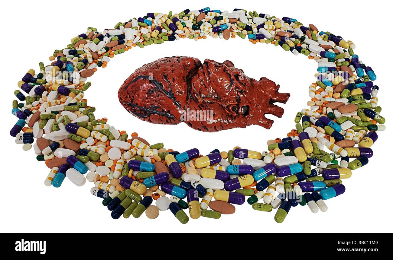 Un modello del cuore umano circondato da pillole Foto Stock