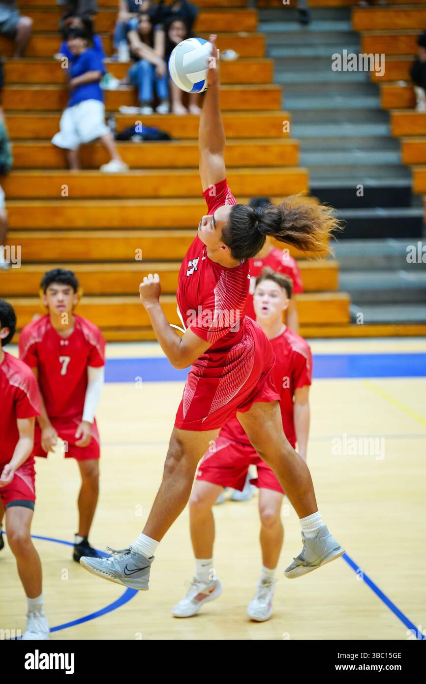 Honolulu, Hawaii, USA – 12 marzo 2025: il giocatore di Kahuku entra in contatto con la palla con la mano destra durante un potente spike contro la Kaiser High School. Foto Stock