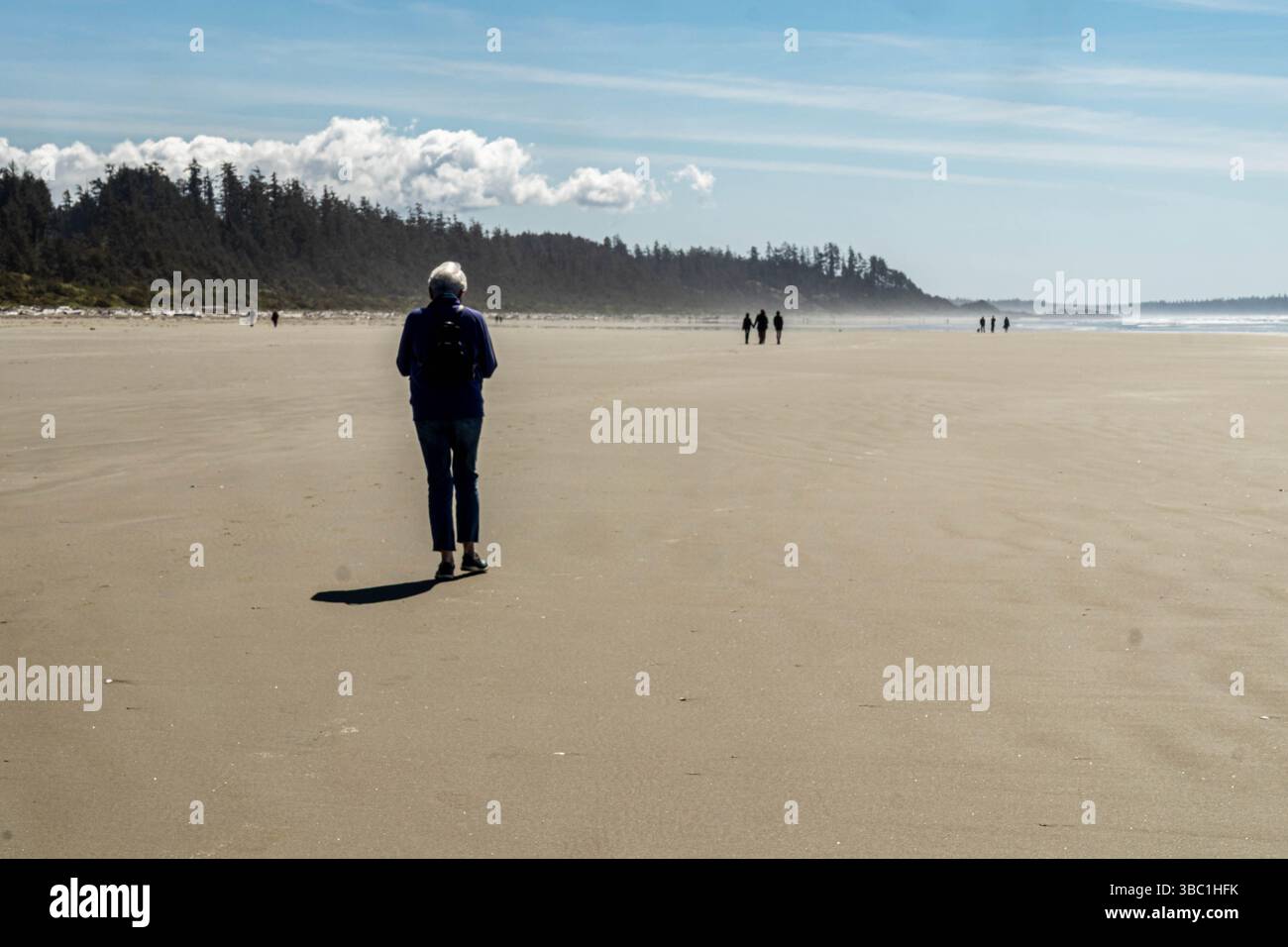Donna che cammina a Long Beach, vicino a Tofino, sulla costa occidentale dell'isola di Vancouver, British Columbia. Foto Stock