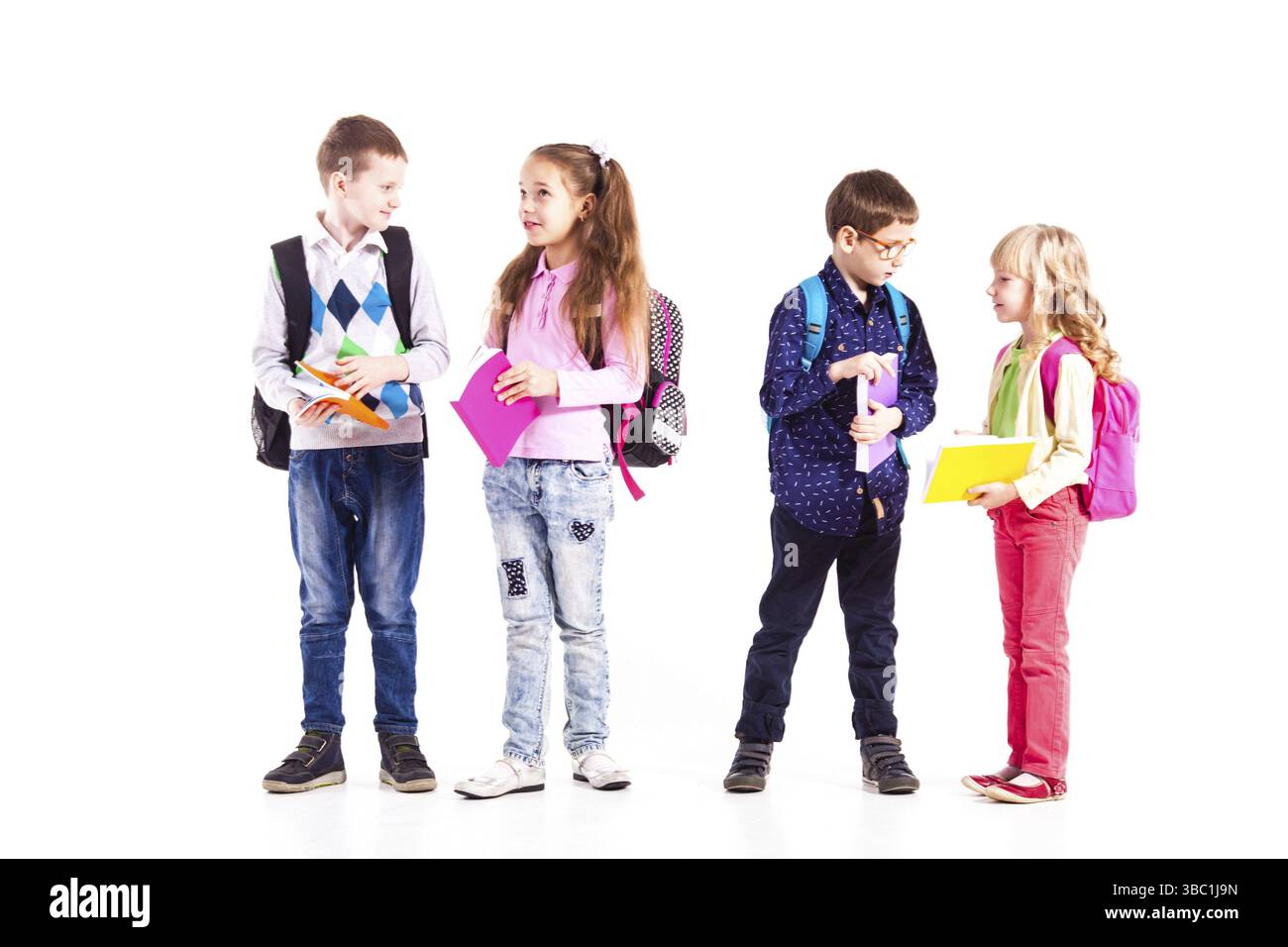 Gli allievi con zaini che tengono i libri nelle mani sono pronti per andare a scuola. Concetto di ritorno a scuola Foto Stock