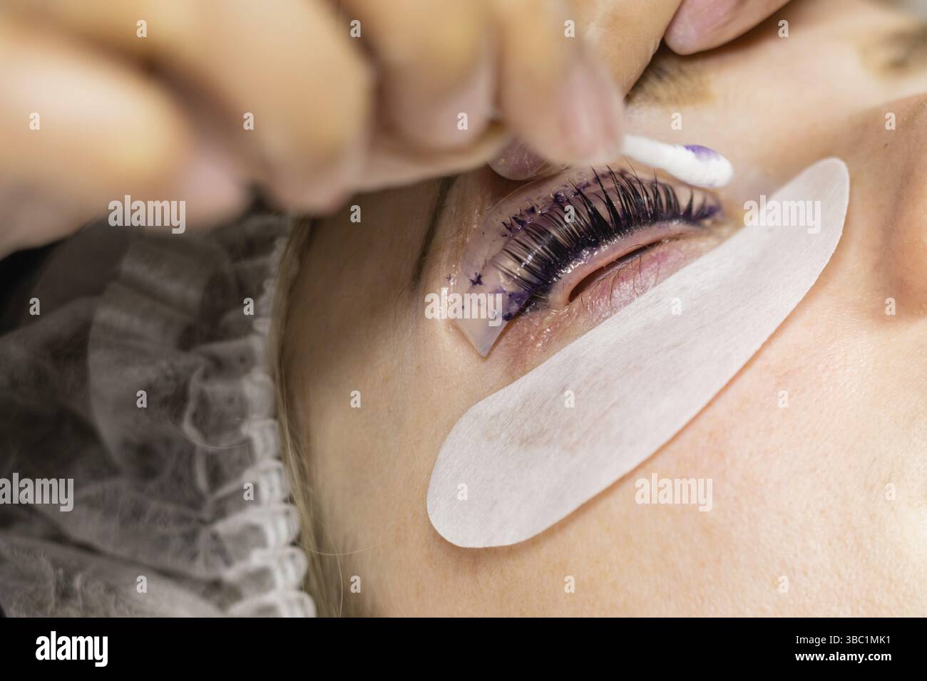 Faccia femminile sotto procedura di laminazione ciglia in salone di bellezza, primo piano Foto Stock