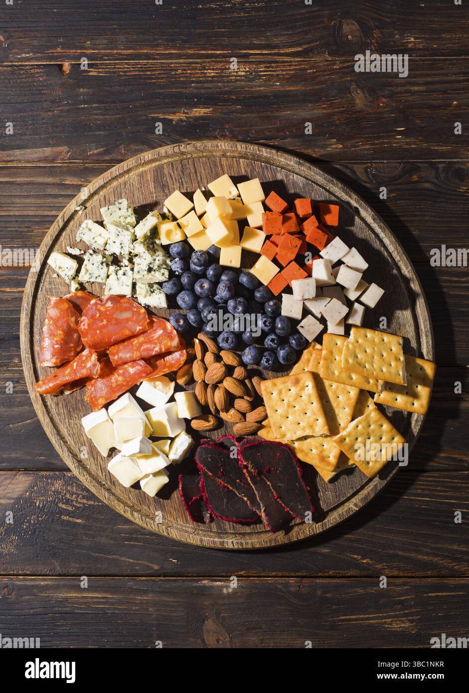 Vista dall'alto di vari snack salati su un piedistallo rotondo in legno Foto Stock