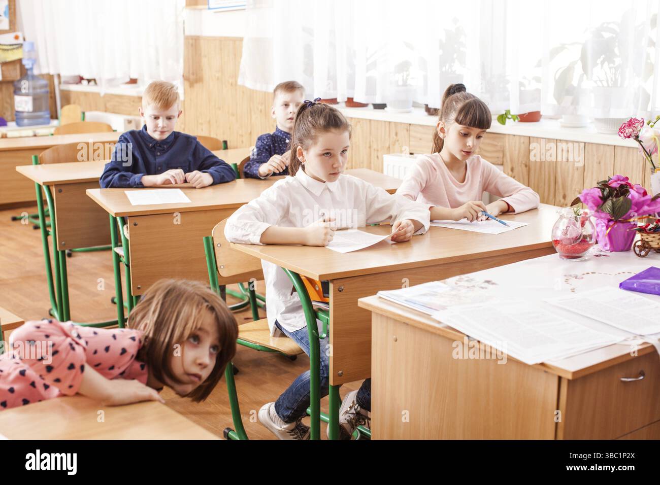 I bambini della scuola primaria che prendono un test della scuola di scrittura dell'esame Foto Stock
