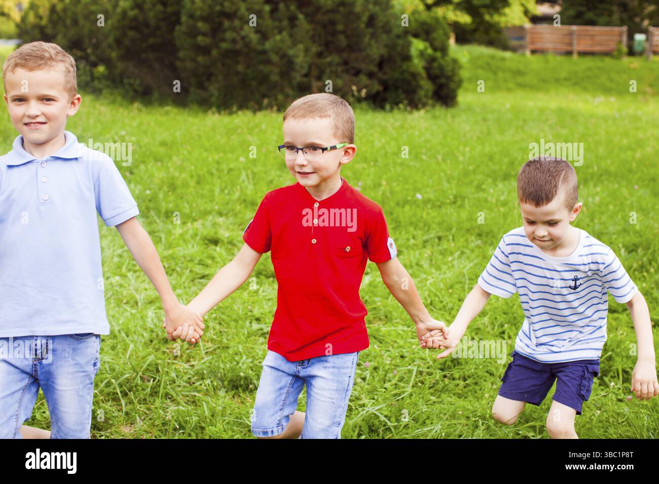 I ragazzi giocano a squadre all'aperto nelle giornate di sole in un campo estivo Foto Stock