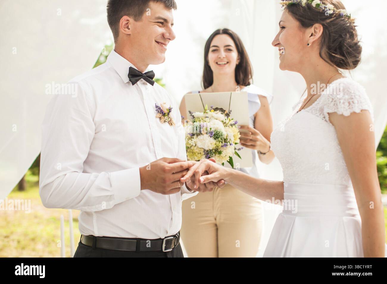 Spose, dove lo sposo indossa un anello su una sposa del dito. Focus sulle mani Foto Stock