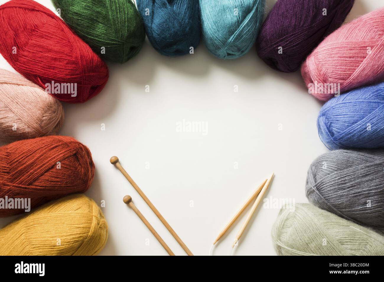 Palle di filato colorate e aghi per maglieria con spazio copia Foto Stock
