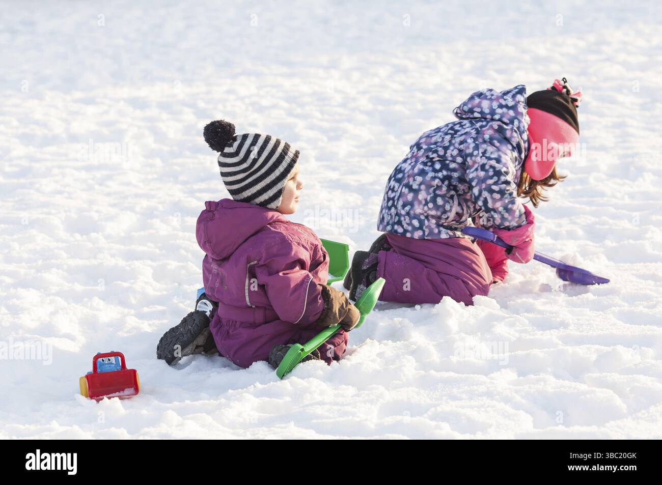 I bambini giocano con le automobili e pale. Città di neve il concetto di pulizia Foto Stock