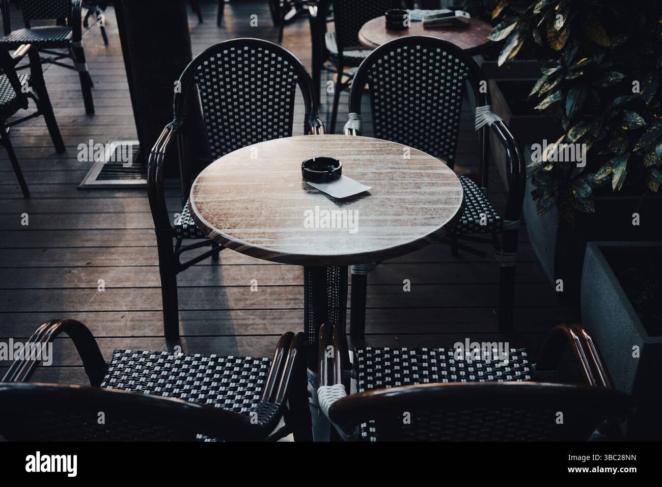 Tavoli e sedie vuoti nel giardino del ristorante di giorno, stagione primaverile, stile vintage. Foto Stock