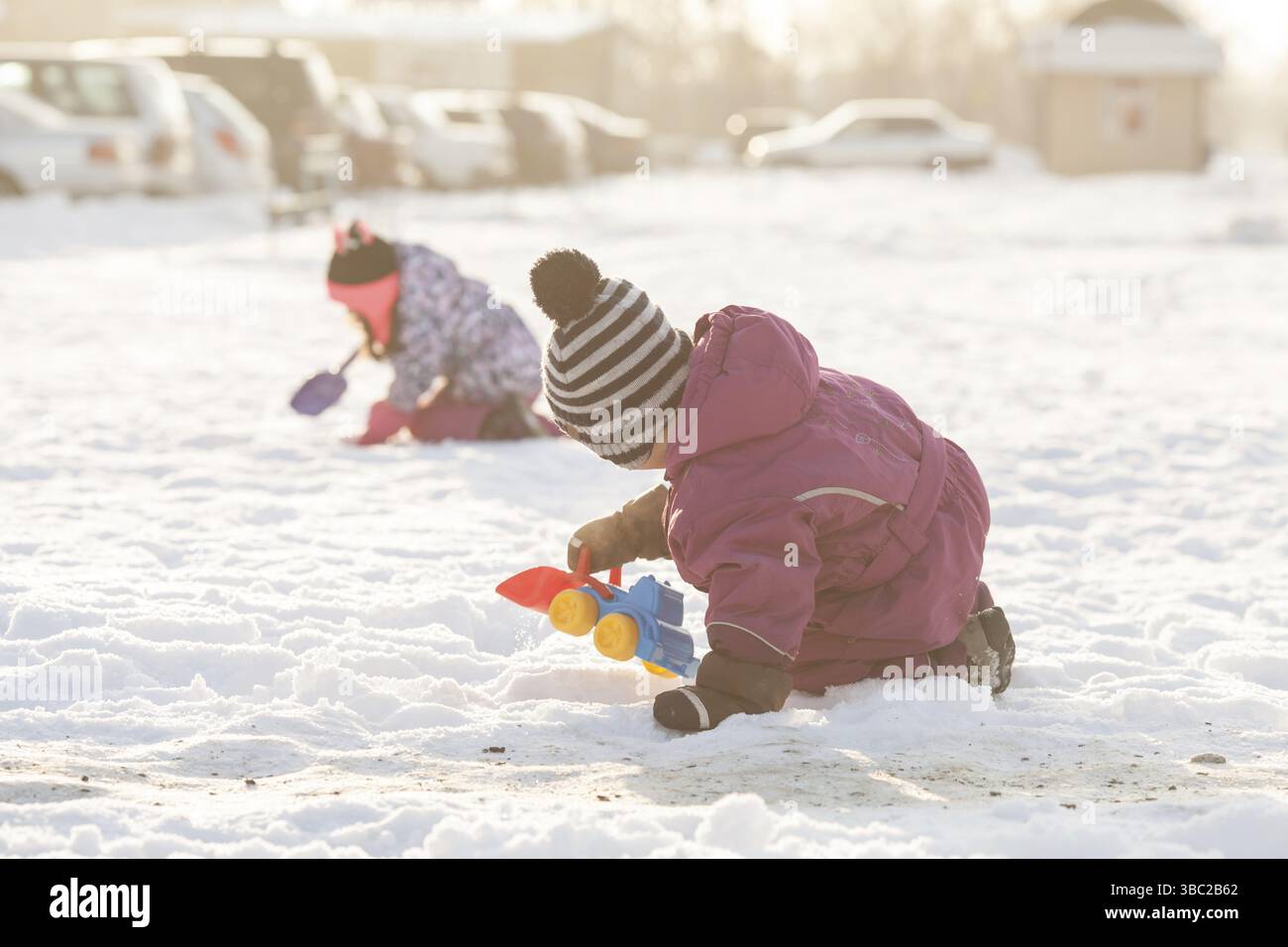 I bambini giocano con le automobili e pale. Città di neve il concetto di pulizia Foto Stock