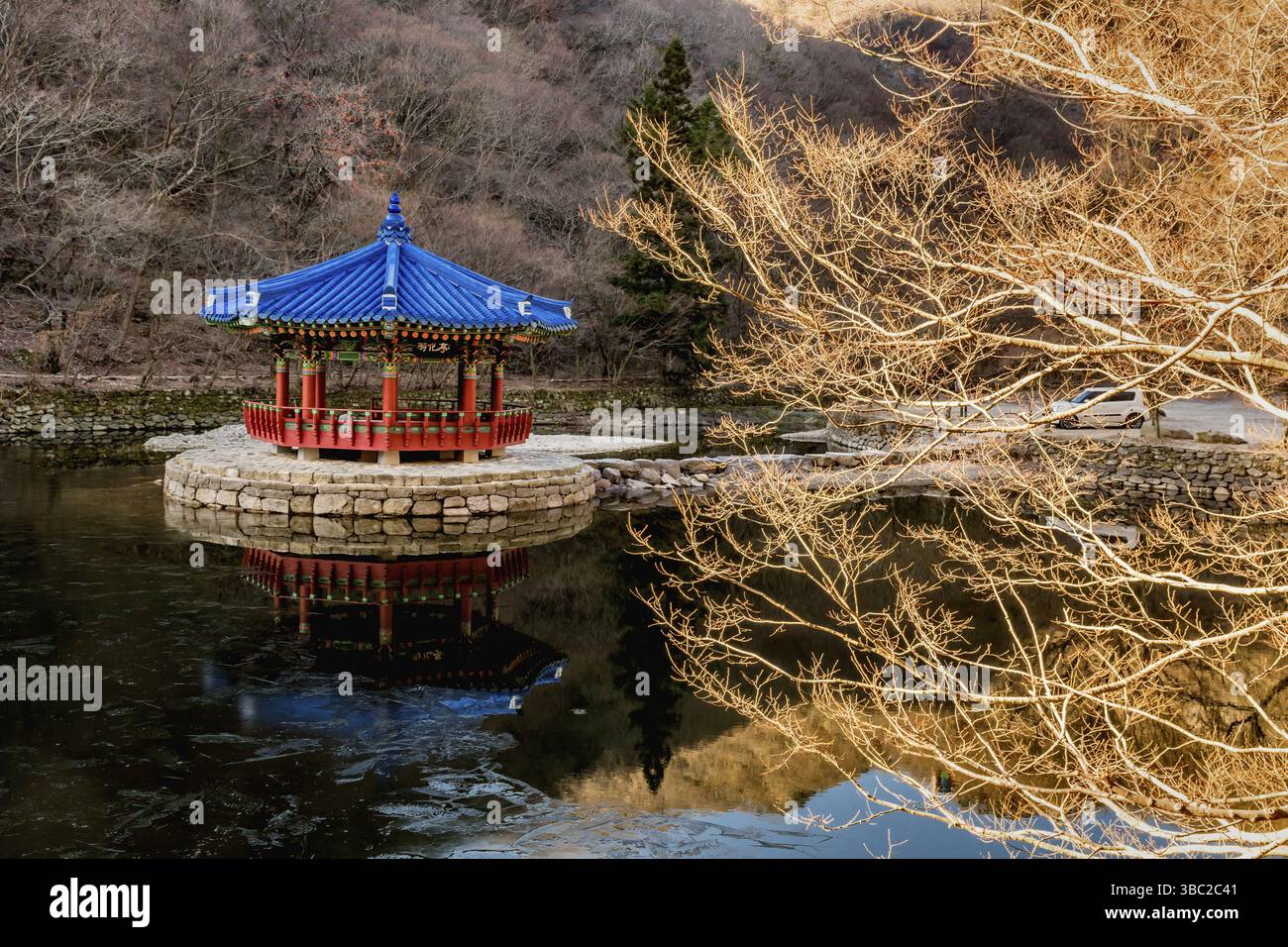 Jeongeup-si, Corea del Sud. 8 dicembre 2020: Padiglione per picnic con tetto blu su un'isola di pietra al centro dello stagno Foto Stock