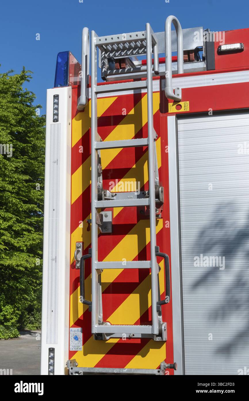 Primo piano della scala di un camion antincendio e delle strisce riflettenti, che sottolineano la sicurezza e la preparazione alle emergenze Foto Stock
