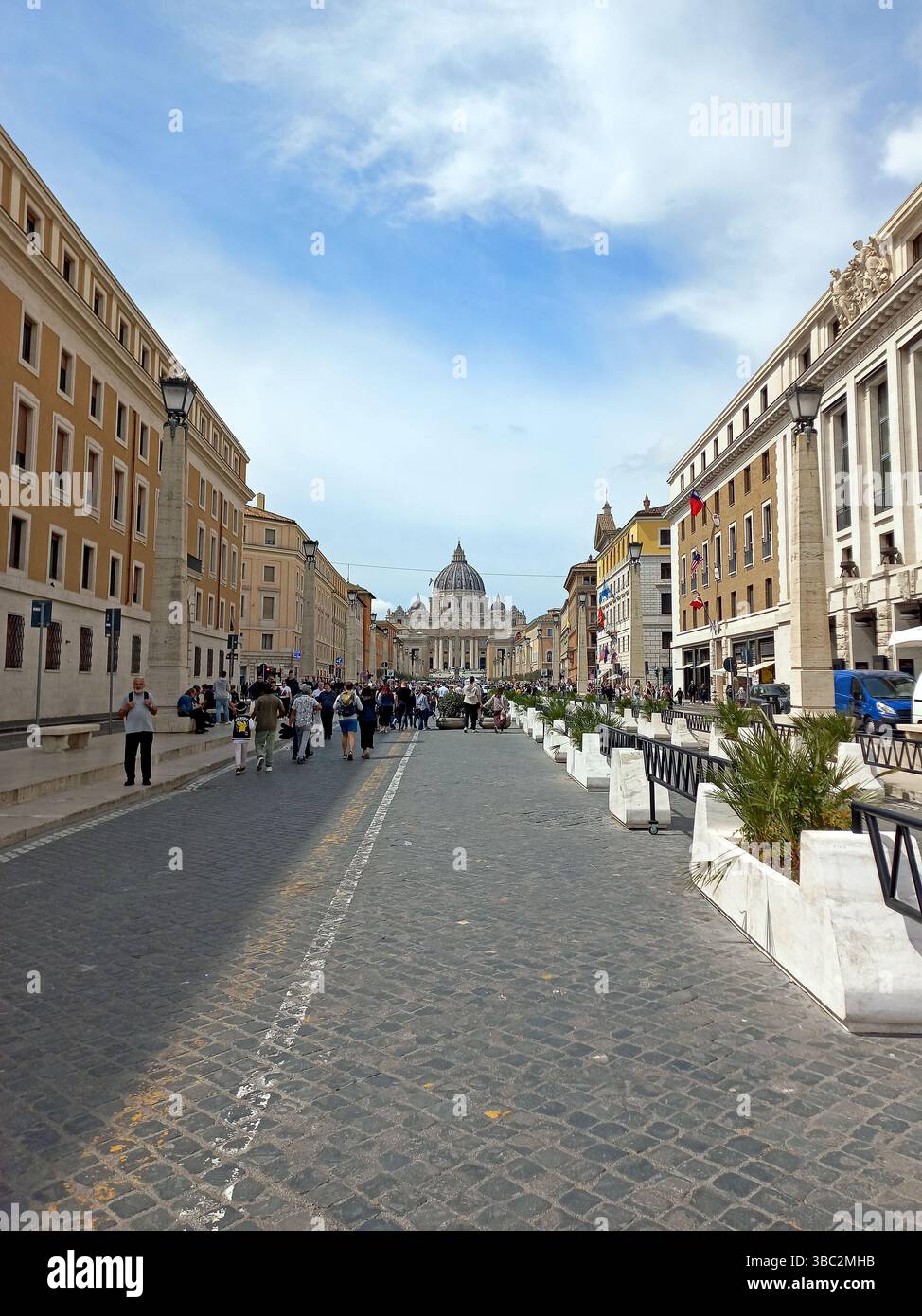 Città del Vaticano. 12 aprile 2025. La gente cammina lungo via della conciliazione verso la cupola e la facciata della Basilica di San Pietro in Vaticano Foto Stock