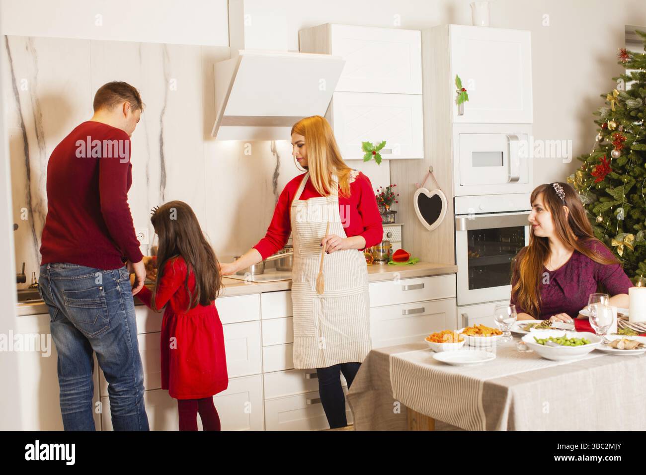 Giovane famiglia cucinano insieme in cucina, preparazione alla vigilia di Natale, incontro di famiglia, tempo insieme Foto Stock