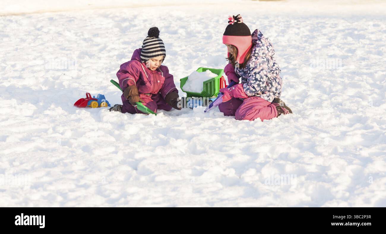 I bambini giocano con le automobili e pale. Città di neve il concetto di pulizia Foto Stock