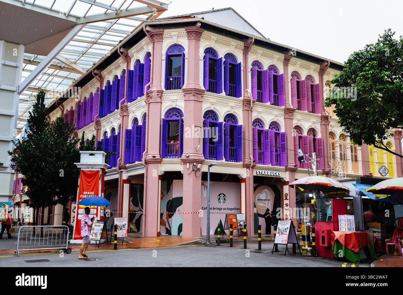 Singapore, Singapore - 4 aprile 2025: Immagine editoriale di un colorato edificio in stile coloniale con vivaci persiane a Little India, Singapore, con Foto Stock