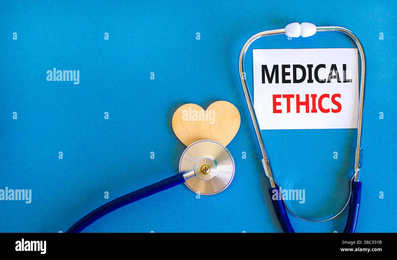 Simbolo di etica medica. Parole concettuali etica medica su bella carta bianca. Cuore in legno e stetoscopio. Bellissimo sfondo blu. Salute medica Foto Stock