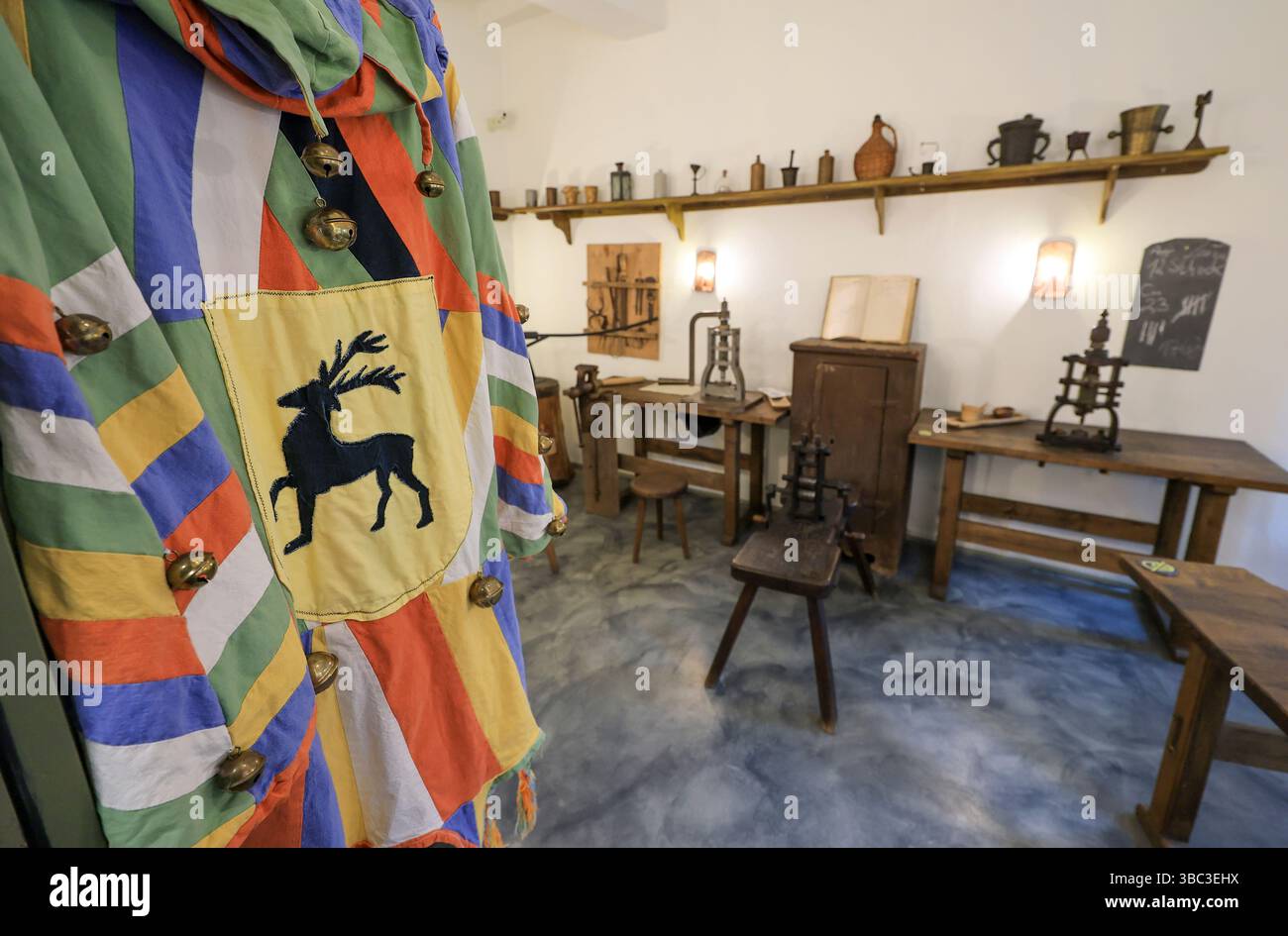 Stolberg, Germania. 16 maggio 2025. La veste storica dell'apprendista maestro di menta con il cervo come animale araldico è appesa nel laboratorio del museo "alte Münze". Il museo nel cuore della città per metà in legno è stato ricostruito e il suo contenuto è stato riorganizzato. Il risultato sono tre mostre sulla guerra dei contadini: "Dall'argento alla moneta", "Thomas Müntzer - figlio della città di Stolberg" e "officina di Stolberg". Crediti: Jan Woitas/dpa/Alamy Live News Foto Stock