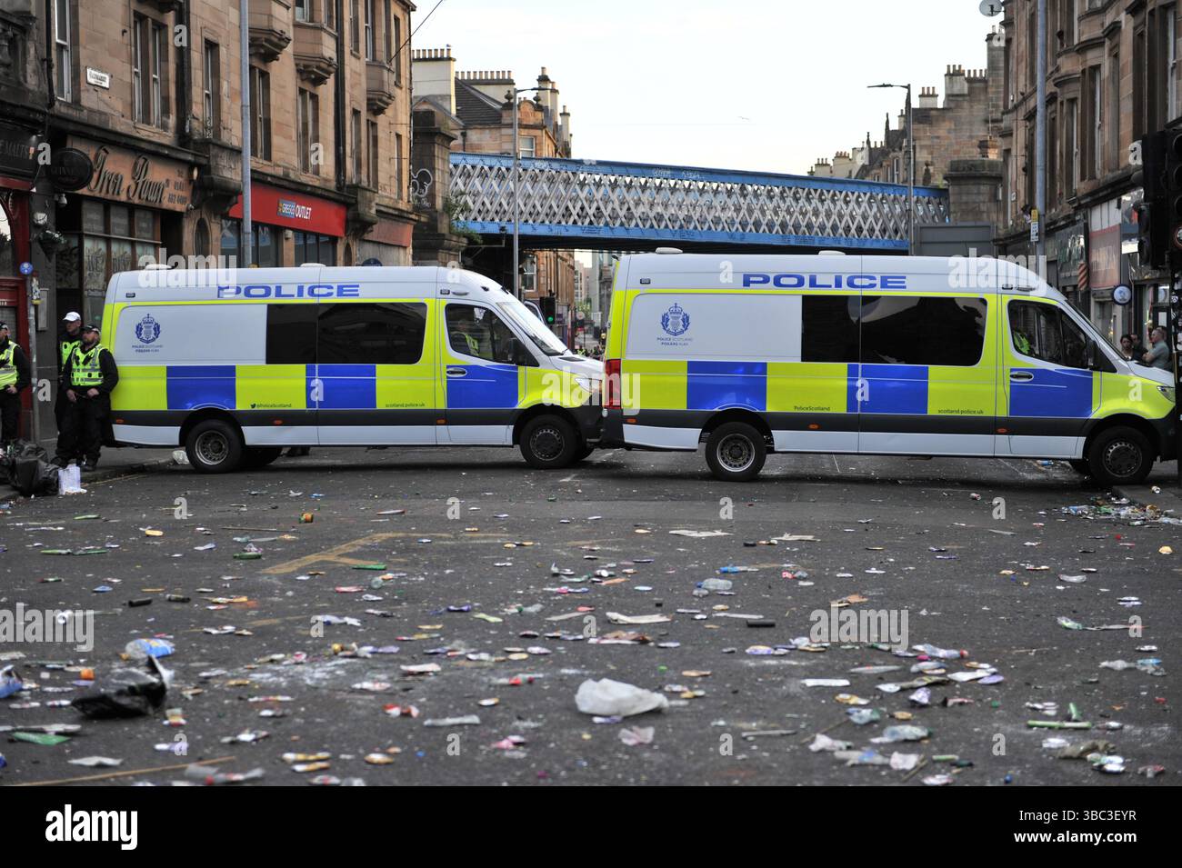 Glasgow, Regno Unito. 17 maggio 2025 - i furgoni della polizia di Scozia per l'ordine pubblico bloccano la strada mentre la polizia si muove per liberare i visitatori da Trongate. I tifosi del Celtic si sono riuniti nel centro di Glasgow il 17 maggio per celebrare la vittoria della Scottish Premiership dopo la vittoria della squadra. I sostenitori hanno allagato le aree della città Mercantile e di Trongate in uno spettacolo di festa vivace ma tranquillo. Crediti: Eastern Goodwin Media/Alamy Live News Foto Stock Glasgow, Regno Unito. 17 maggio 2025 - i furgoni della polizia di Scozia per l'ordine pubblico bloccano la strada mentre la polizia si muove per liberare i visitatori da Trongate. I tifosi del Celtic si sono riuniti nel centro di Glasgow il 17 maggio per celebrare la vittoria della Scottish Premiership dopo la vittoria della squadra. I sostenitori hanno allagato le aree della città Mercantile e di Trongate in uno spettacolo di festa vivace ma tranquillo. Crediti: Eastern Goodwin Media/Alamy Live News Foto Stock