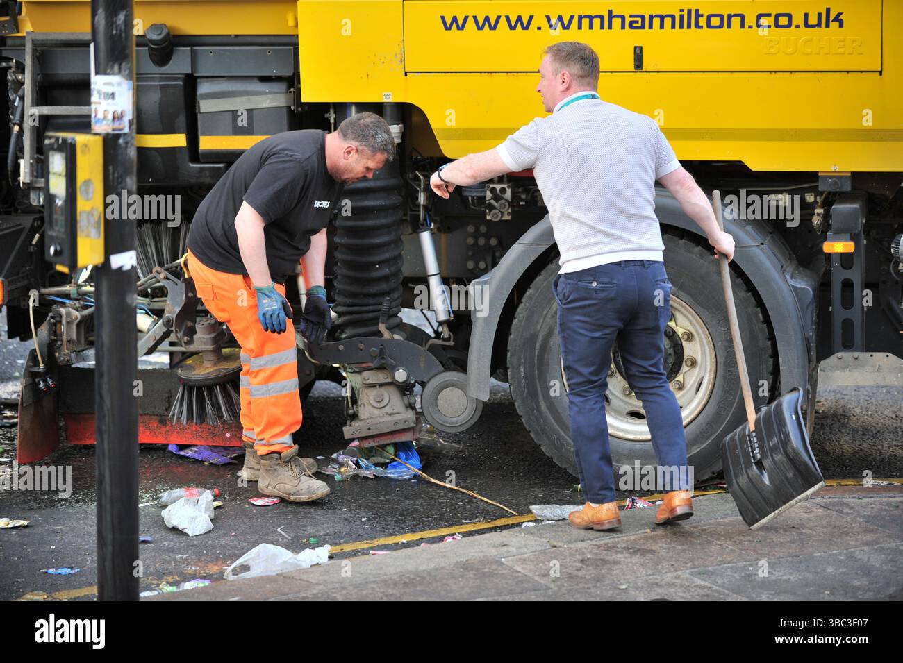Glasgow, Regno Unito. 17 maggio 2025 - Un consigliere viene visto con una pala da neve per aiutare a liberare l'area aiutando a sbloccare una spazzatrice stradale. I tifosi del Celtic si sono riuniti nel centro di Glasgow il 17 maggio per celebrare la vittoria della Scottish Premiership dopo la vittoria della squadra. I sostenitori hanno allagato le aree della città Mercantile e di Trongate in uno spettacolo di festa vivace ma tranquillo. Crediti: Eastern Goodwin Media/Alamy Live News Foto Stock Glasgow, Regno Unito. 17 maggio 2025 - Un consigliere viene visto con una pala da neve per aiutare a liberare l'area aiutando a sbloccare una spazzatrice stradale. I tifosi del Celtic si sono riuniti nel centro di Glasgow il 17 maggio per celebrare la vittoria della Scottish Premiership dopo la vittoria della squadra. I sostenitori hanno allagato le aree della città Mercantile e di Trongate in uno spettacolo di festa vivace ma tranquillo. Crediti: Eastern Goodwin Media/Alamy Live News Foto Stock