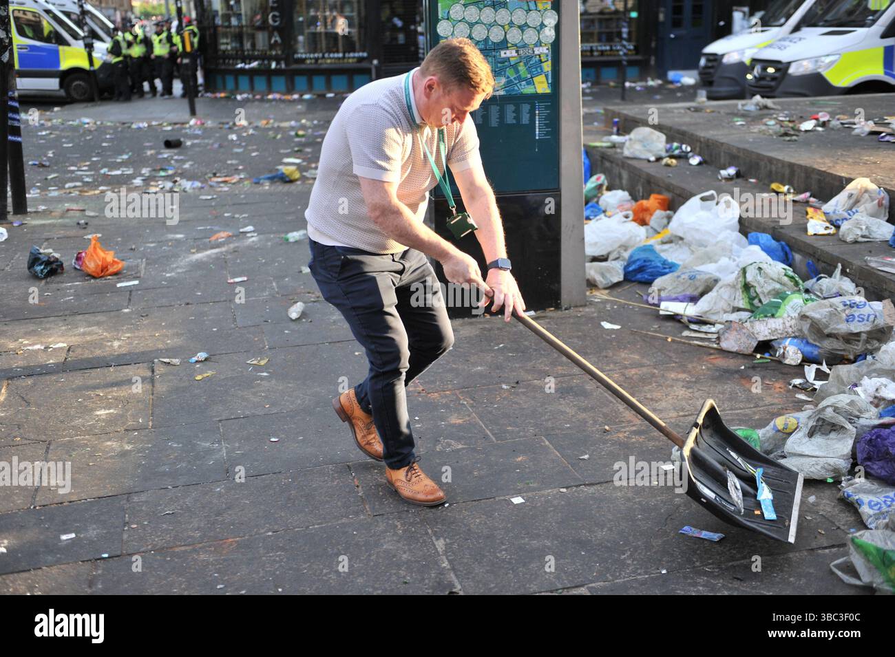 Glasgow, Regno Unito. 17 maggio 2025 - Un consigliere viene visto con una pala da neve per aiutare a liberare l'area. I tifosi del Celtic si sono riuniti nel centro di Glasgow il 17 maggio per celebrare la vittoria della Scottish Premiership dopo la vittoria della squadra. I sostenitori hanno allagato le aree della città Mercantile e di Trongate in uno spettacolo di festa vivace ma tranquillo. Crediti: Eastern Goodwin Media/Alamy Live News Foto Stock Glasgow, Regno Unito. 17 maggio 2025 - Un consigliere viene visto con una pala da neve per aiutare a liberare l'area. I tifosi del Celtic si sono riuniti nel centro di Glasgow il 17 maggio per celebrare la vittoria della Scottish Premiership dopo la vittoria della squadra. I sostenitori hanno allagato le aree della città Mercantile e di Trongate in uno spettacolo di festa vivace ma tranquillo. Crediti: Eastern Goodwin Media/Alamy Live News Foto Stock