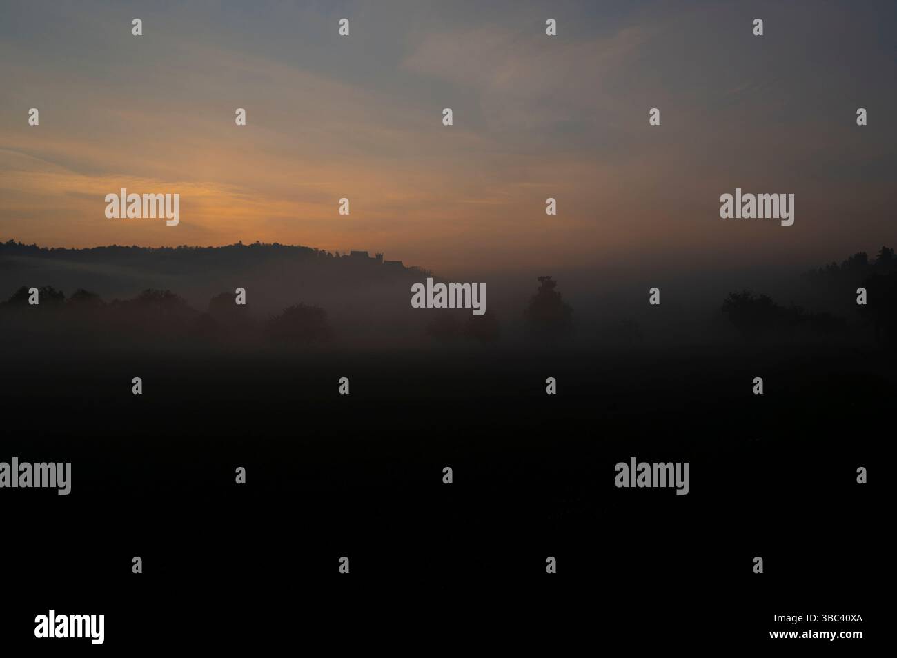 Nebbia al sorgere del sole con il castello di Weitenburg sullo sfondo nel paesaggio della valle del Neckar vicino a Rottenburg am Neckar in Germania. Foto Stock