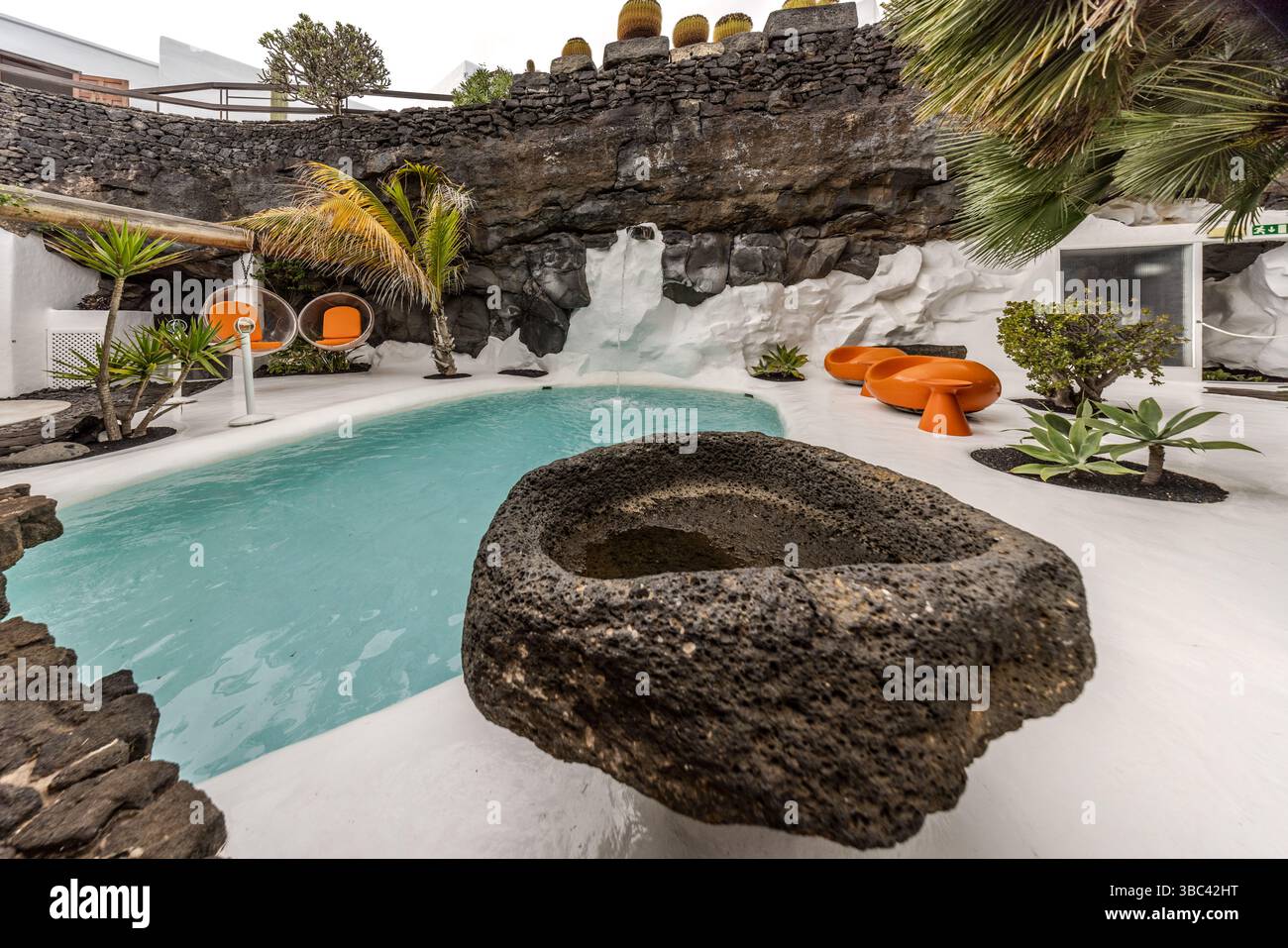 Area esterna della Fondazione César Manrique a Lanzarote con piscina e sedie sospese di colore arancione. Calle Jorge Luis Borges, Teguise, Canarias, Spagna Foto Stock