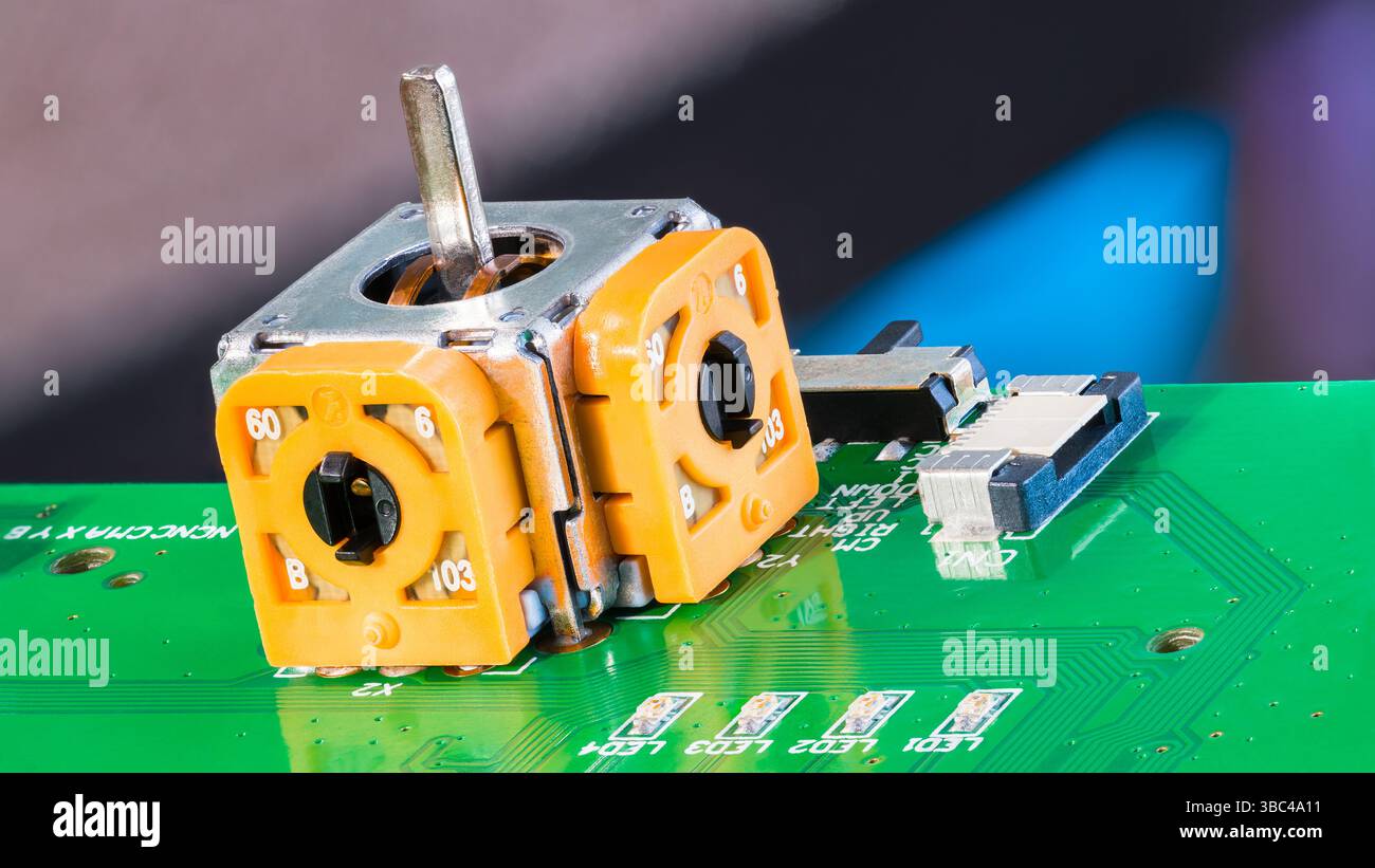 Primo piano del modulo sensore analogico asse joystick su PCB verde. Interruttore e diodi luminosi a LED a montaggio superficiale con levetta o connettore 3D di controllo giallo. Foto Stock