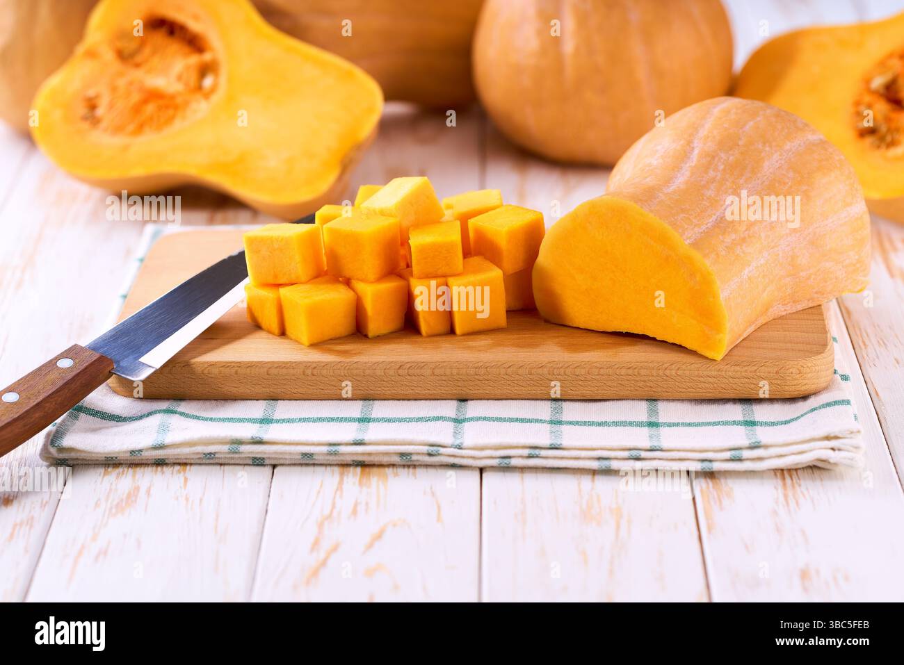 Zucca a cubetti su tagliere in legno spazio per copiare il testo. Foto Stock