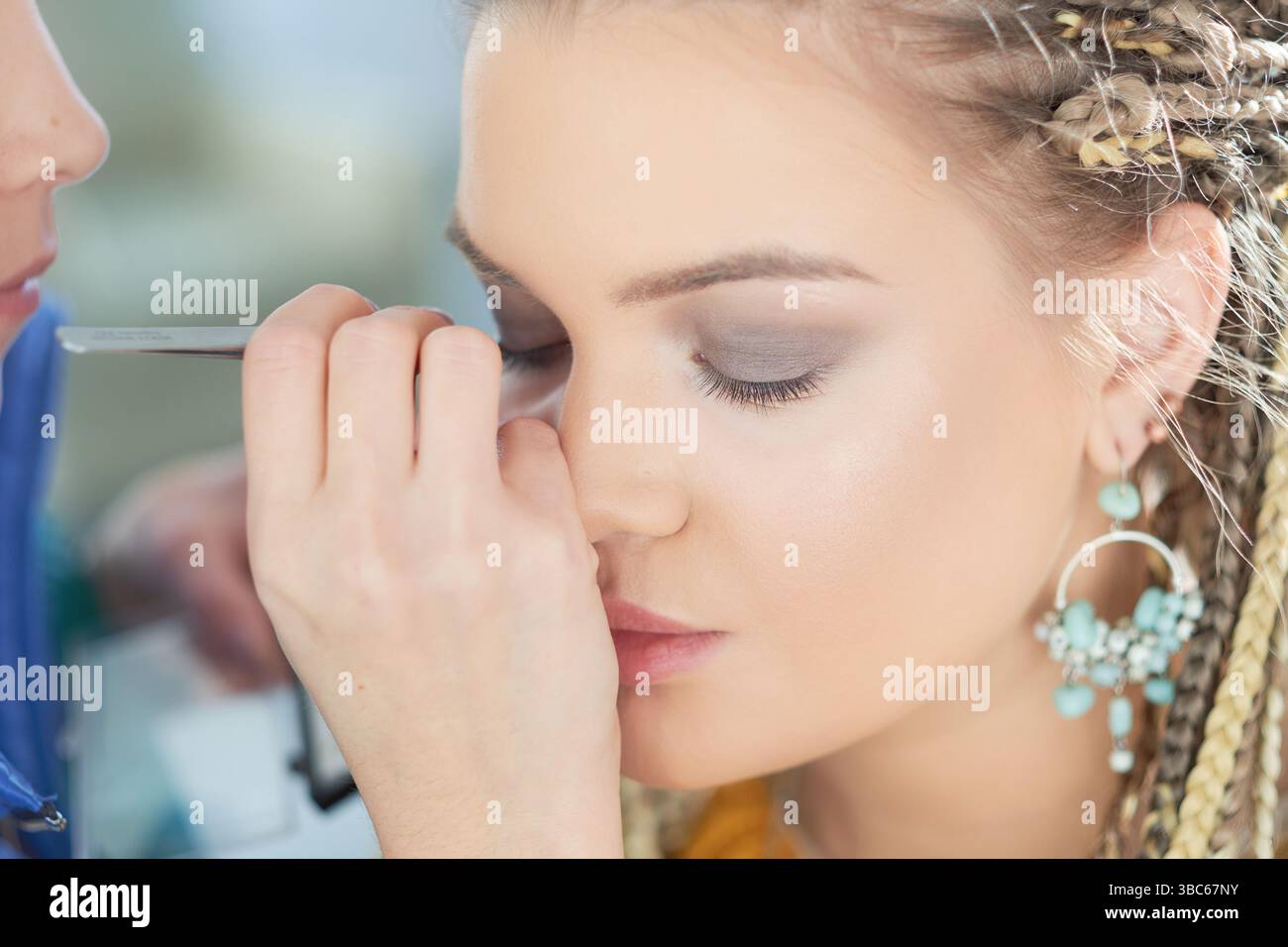 Dettaglio macro del modello caucasico ciglia false durante la sessione di trucco. Foto Stock