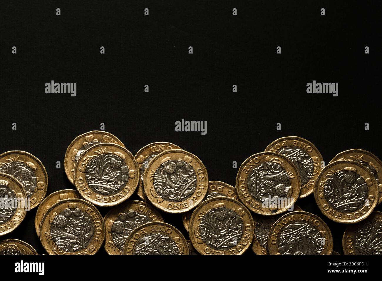 Monete inglesi sparse da una sterlina costeggiate sul fondo di uno sfondo nero, simboleggiando risparmi, ricchezza e valuta del Regno Unito, Stafford, Regno Unito Foto Stock