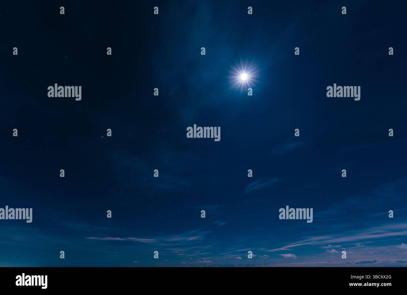 La luna risplende nel cielo notturno con stelle e nuvole Foto Stock